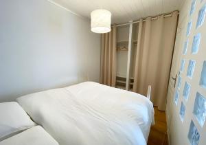 a bedroom with a white bed and a light at Charmant appartement rénové au cœur de Concarneau in Concarneau +2 photos