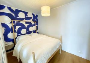a bedroom with a bed with a blue and white wall at Charmant appartement rénové au cœur de Concarneau in Concarneau