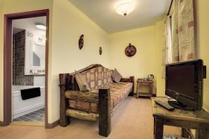 a living room with a couch and a tv at Lowthwaite B&B in Watermillock