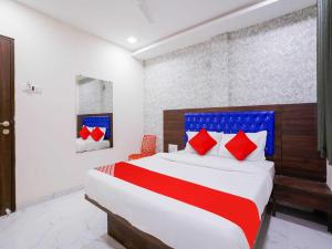 een slaapkamer met een groot bed met rode en blauwe kussens bij Hotel King Residency in Mumbai