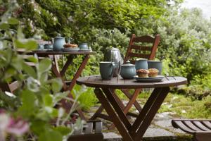 una mesa de picnic con tazas y magdalenas. en Lowthwaite B&B, en Watermillock