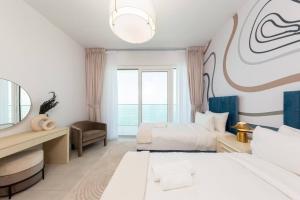 a hotel room with two beds and a mirror at Fantastic and Rare 4BR+maid's in JBR Walk in Dubai