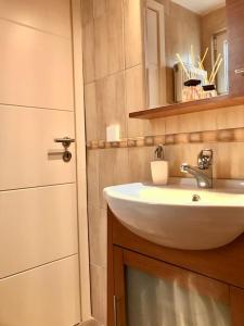 a bathroom with a sink and a door at Bright Top Floor Studio-Apartment in Kalamaki in Athens