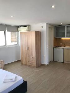 a room with a kitchen and a bedroom with a bed at Bright Top Floor Studio-Apartment in Kalamaki in Athens