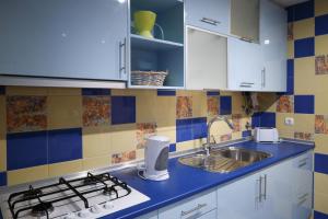 La cuisine est équipée de placards blancs, d'un évier et d'une cuisinière. dans l'établissement Apartamentos da Orada T2-F 010 Marina de Albufeira, à Páteo