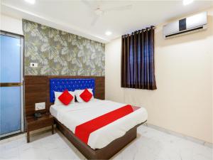 Hotel King Residency في مومباي: غرفة نوم بسرير كبير ومخدات حمراء