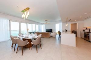 a dining room and living room with a table and chairs at Fantastic and Rare 4BR+maid's in JBR Walk in Dubai