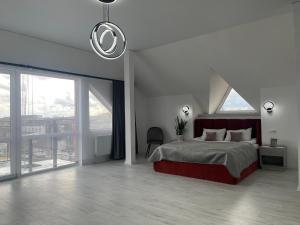 ein Schlafzimmer mit einem großen Bett und einem großen Fenster in der Unterkunft Hotel Femina in Schytomyr