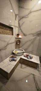 Cette chambre en marbre blanc dispose d'une horloge et d'une table. dans l'établissement ihlamur konağı Junior villas, à Sapanca