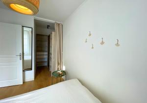 a white bedroom with a bed and a mirror at Charmant appartement rénové au cœur de Concarneau in Concarneau