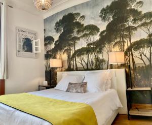 リュソンにあるLa Villa des Roses Gîte Chambres d'hôtes Piscine chaufféeのベッドルーム1室(壁に絵画が描かれた大型ベッド1台付)