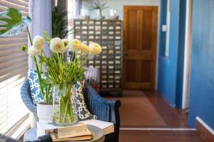 stół z wazonem kwiatów w obiekcie Loddey`s Guest House - by Beach Collection w mieście Strand