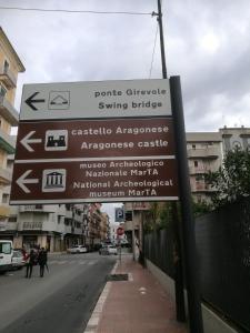 un cartello stradale con frecce sul lato di una strada di SETTIMO SOLE Affitta Camere a Taranto