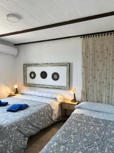 a bedroom with two beds and two lamps on tables at Casa Rural Quejigo con piscina in Santa Olalla del Cala +36 photos