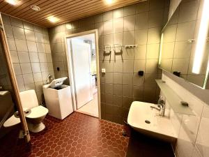 een badkamer met een toilet, een wastafel en een spiegel bij Vuokatti Weekend Piste in Vuokatti +32 foto's