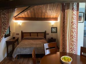 Un dormitorio con una cama y una mesa con un bol de fruta en Casa rural en Redes para 4 en Ríoseco