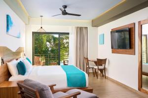 a bedroom with a bed and a table and chairs at Cristalino Lagoon Front Hotel, Restaurant & Spa in Bacalar