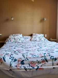 een bed met een bloemdekbed en 2 kussens bij Villa de 3 chambres avec piscine privee jardin clos et wifi a Aubignan in Aubignan