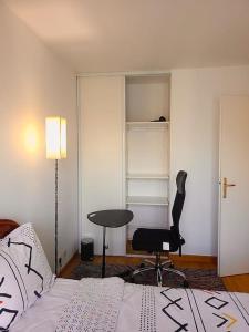 a bedroom with a bed and a desk and a chair at Cozy haven near Paris La Defense Grande Arche in Courbevoie