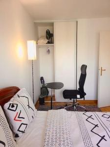 a bedroom with a bed and a chair and a table at Cozy haven near Paris La Defense Grande Arche in Courbevoie