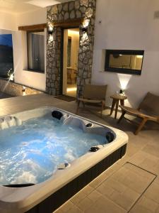 a jacuzzi tub in the middle of a room at Lithos Luxury Villa in Archangelos