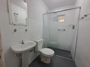 a bathroom with a toilet and a sink and a shower at Linda Casa 4 qts churrasqueira Prainha Mambucaba in Paraty +28 photos