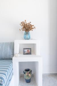 a white table with a vase on top of it at Tinos Sunset Villa in Kékhros
