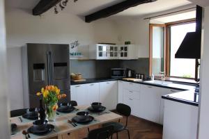 a kitchen with a table and a refrigerator at Casa Di Sylvia-enjoy tranquility and amazing views in Coreglia Antelminelli
