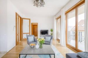 uma sala de estar com duas cadeiras e uma mesa em Dream Home with Grand Terrace in the City Center em Budapeste