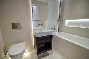 a bathroom with a toilet and a sink and a tub at Cosmopolitan Hideaway in London