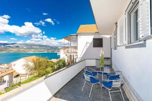 a balcony with a glass table and chairs on it at Apartman Simic in Trogir