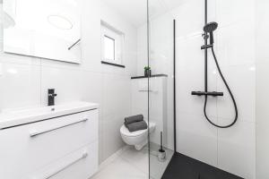 a white bathroom with a shower and a toilet at Apartman Simic in Trogir +16 photos