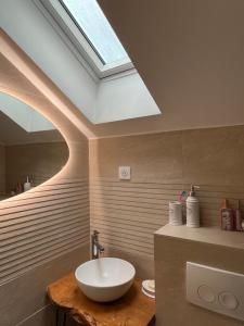 a bathroom with a white sink and a skylight at Maison en pierre avec jacuzzi in Caen