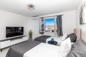 a hotel room with a bed and a television at Apartman Simic in Trogir