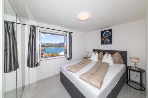 a bedroom with a bed and a large window at Apartman Simic in Trogir