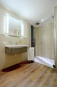 ein Bad mit einem Waschbecken und einer Dusche in der Unterkunft Passepartout in Norderney