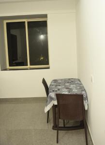 a table and chairs in a room with a window at Sai Homestay Panaji Studio in Panaji