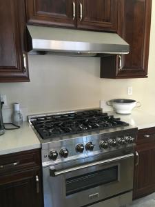 uma placa de fogão com forno numa cozinha com armários de madeira em Canyon crest em Altadena