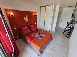 een slaapkamer met een bed met een rood hoofdeinde bij Sweet Crépuscule - Studio avec Vue Mer Imprenable & Piscine in Les Trois-Îlets