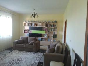uma sala de estar com dois sofás e uma estante de livros em Villa Green House em Shkodër
