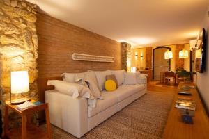 a living room with a white couch and a stone wall at Pousada Literária de Paraty in Paraty