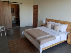 1 dormitorio con 1 cama grande con sábanas y almohadas blancas en Villas Rocher - Standard Suite 2B en Grand Baie