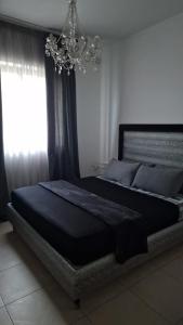 a large bed in a bedroom with a chandelier at St Julian's Central Paceville Apartments in St. Julianʼs