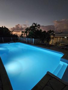 萊斯三河－勒茨的住宿－Sweet Crépuscule - Studio avec Vue Mer Imprenable & Piscine，蓝色照明的大型游泳池