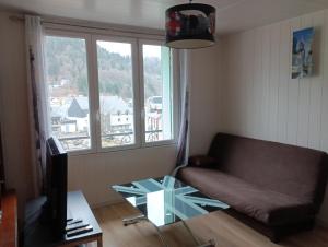 ein Wohnzimmer mit einem Sofa und einem Glastisch in der Unterkunft Mont Dore/Sancy 6 personnes emplacement privilégié in Le Mont-Dore