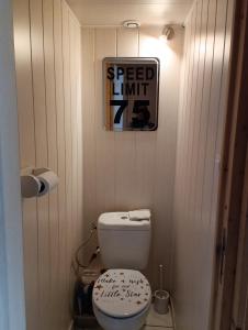 a bathroom with a toilet and a sign on the wall at Mont Dore/Sancy 6 personnes emplacement privilégié in Le Mont-Dore
