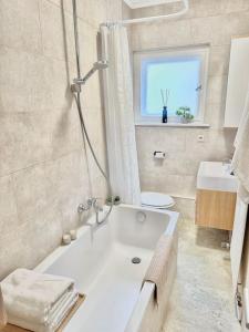 a bathroom with a tub and a sink and a window at 2Room Apartment in Best Place in Berlin