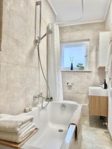 a bathroom with a white tub and a sink at 2Room Apartment in Best Place in Berlin