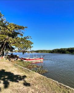 a boat sitting on the water next to a lake at Iguape, Jureia, Barra do Ribeira - Frente ao mar in Iguape +21 photos