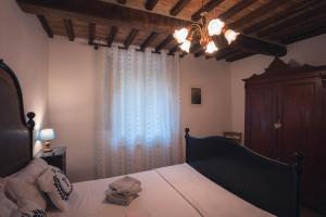 1 dormitorio con 1 cama y una ventana con cortinas en Nature & Relax in Tuscany - Pagiano 2, en Roccastrada